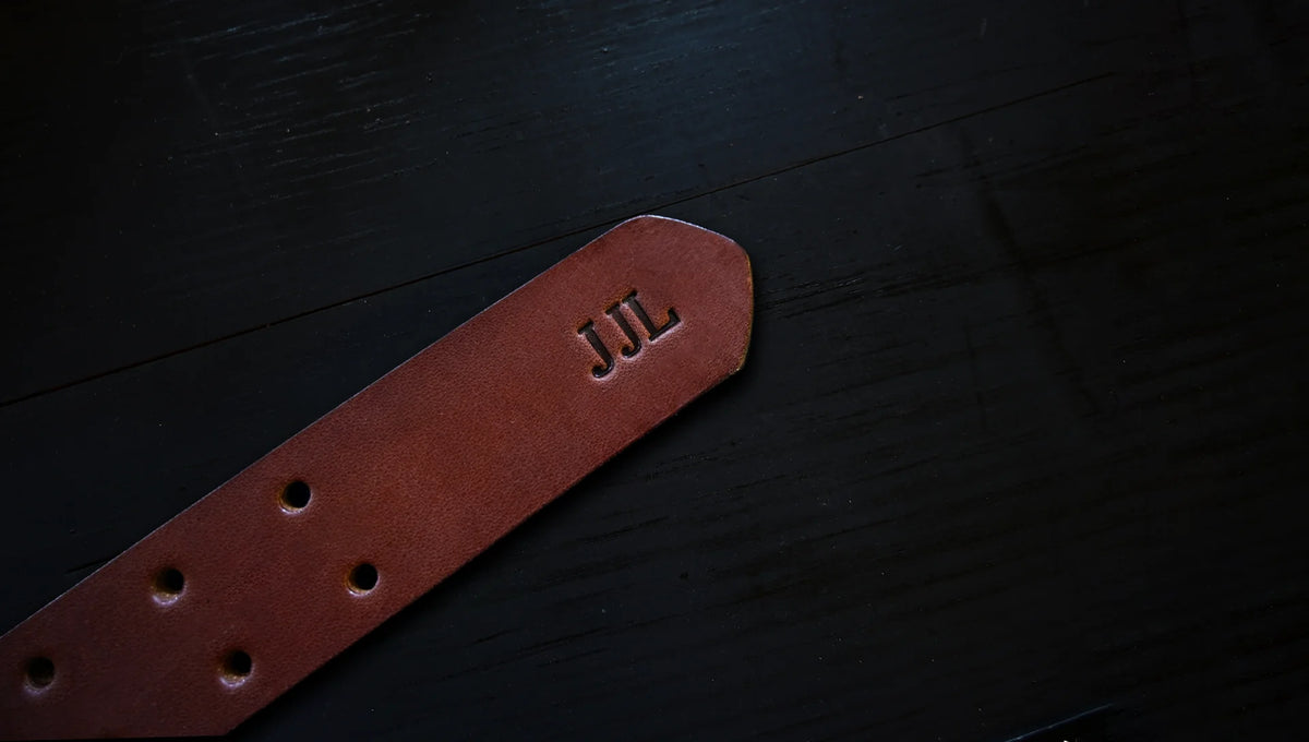 double prong belt personalized with embossed initials, shown as J J L.